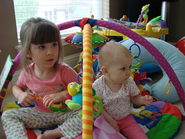 A nine months old baby and her sister playing.
