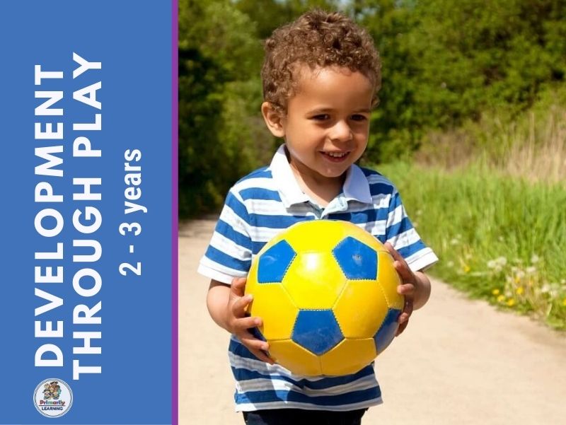 A picture of a 2 or 3 year old child playing with a ball.