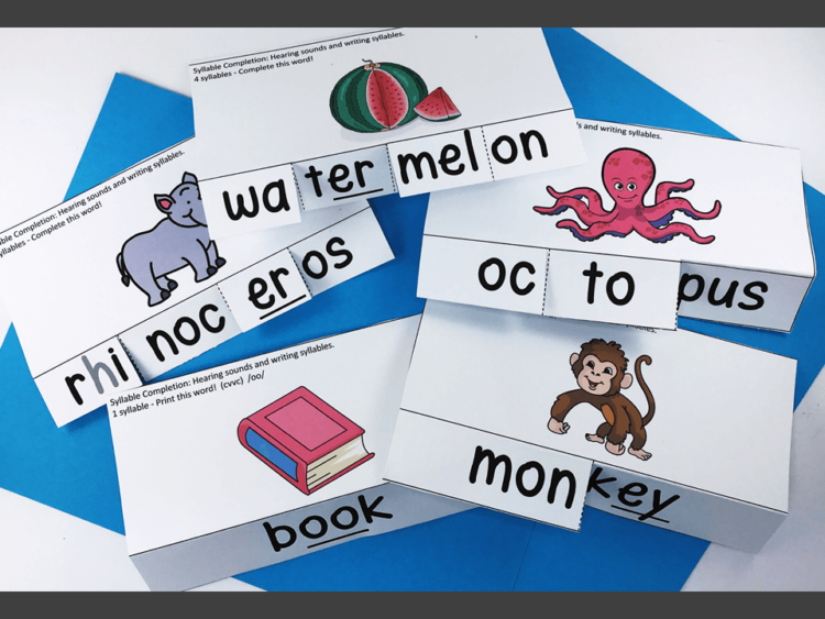 there is a word and picture on a card. the word is cut to show syllables.