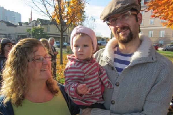 A nine months old with dad and grandma.