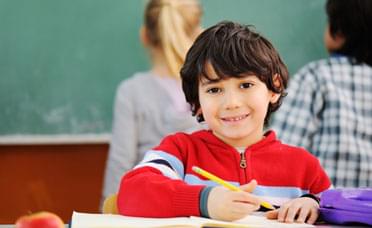A young boy writing his letters and sounds.